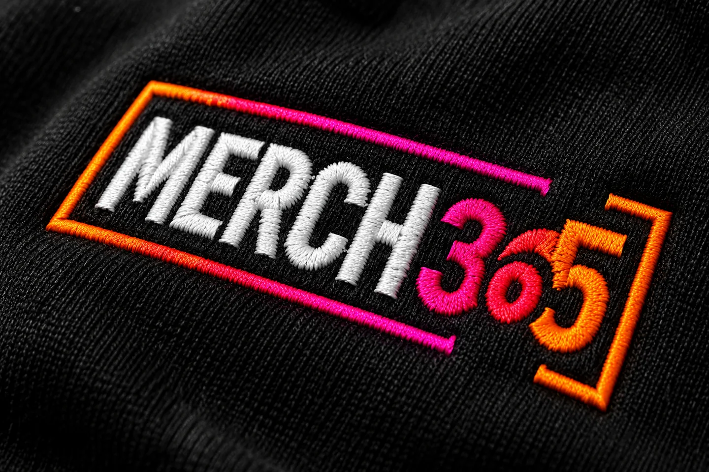 Concept close-up of an embroidered Merch365 logo on black fabric