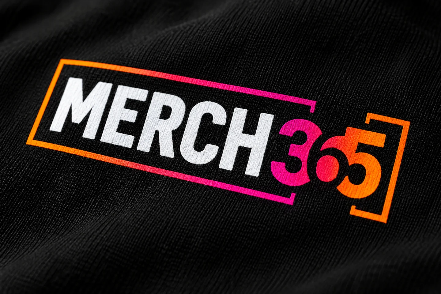 Concept close-up of the Merch365 logo printed on black cotton